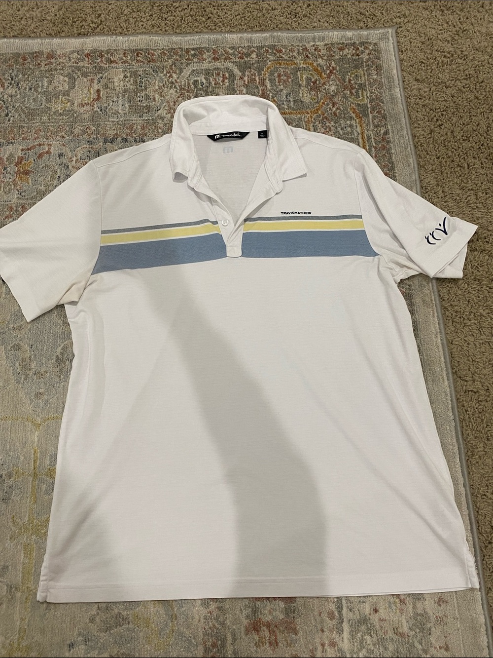 Travis Mathew White Polo with Blue and Yellow Chest Stripes